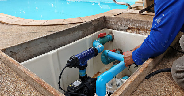 Technician fixing swimming pool water pump. Service and maintenance for swimming pool.